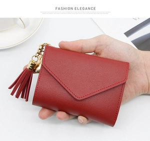 Close-up of a red lychee pattern leather envelope wallet featuring a metal tassel charm