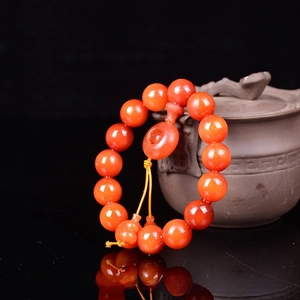 Detailed macro of 15mm Amber wood oil-infused beads with gourd pendant on black mirror