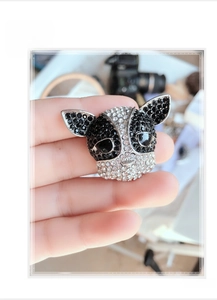 Detailed view of French Bulldog brooch with black and white rhinestones held in hand