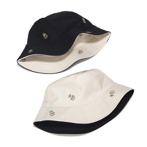 Close-up of pineapple embroidery details on black and beige cotton bucket hats
