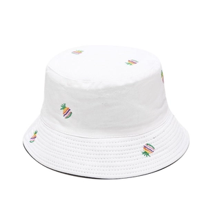 Close-up of colorful pineapple embroidery detail on white cotton bucket hat fabric