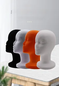 Detail of four flocked foam mannequin heads in black, grey, orange and white colors