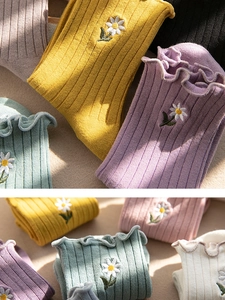 Detail of sweet cotton socks featuring daisy embroidery and stylish frilly ruffle cuffs