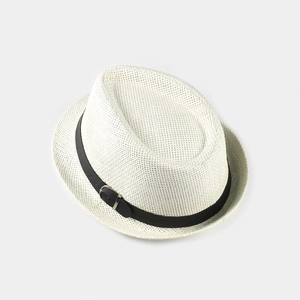 Detail of summer straw jazz hat featuring a beige woven texture and black leather strap