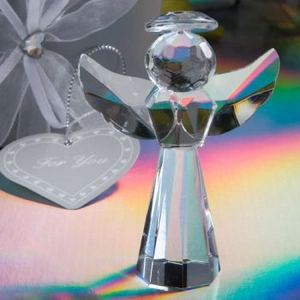 Macro shot of faceted crystal angel figurine with silver For You heart tag on organza bag