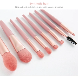 Detail of 8 pink makeup brushes with synthetic hair and rose gold ferrules on white