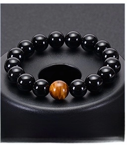 Close-up of polished black agate beaded bracelet with a single tiger eye stone detail