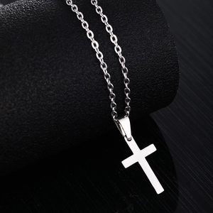 Collier avec pendentif croix en acier inoxydable argenté sur un élégant socle noir