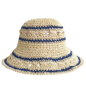 Detailed view of handmade beige straw bucket hat with navy blue woven stripe and textures