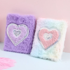 Detail of plush unicorn notebooks with sequined heart covers in purple and rainbow colors