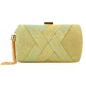 Dettaglio pochette da sera intrecciata con trama oro e verde ed eleganti nappe a catena