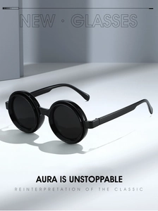 Detail einer runden schwarzen Sonnenbrille mit strukturiertem Rahmen und dunklen Gläsern