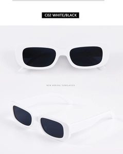 Close-up of retro rectangular sunglasses with thick white frames and dark black lenses