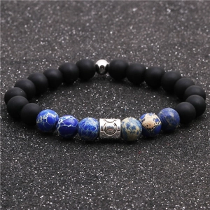 Close-up of Taurus zodiac bead on matte black and blue marble beaded couple bracelet