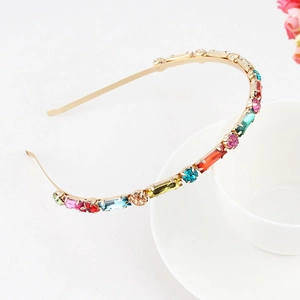 Detail of thin gold headband with colorful rhinestones and imitation pearls