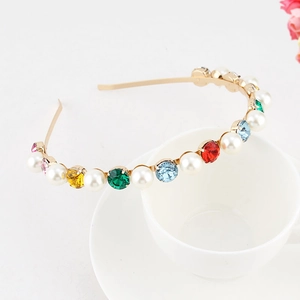Detailed shot of multi-color crystals and faux pearls on a gold metal baroque headband