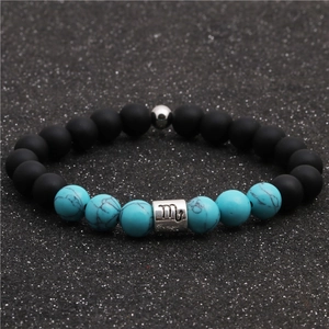 Detail of Scorpio charm on matte black and turquoise beaded bracelet for couples