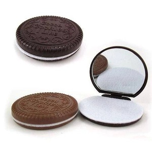 Detail of mini chocolate cookie compact mirror and comb set in brown finish