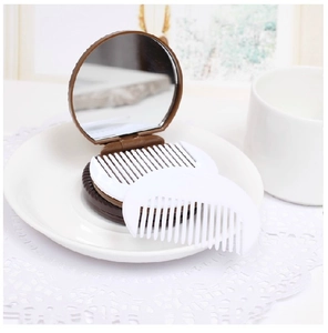 Mini chocolate biscuit folding mirror and comb set displayed on a white ceramic plate