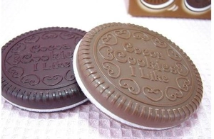 Detail shot of mini chocolate cookie pocket mirror and comb with heart pattern