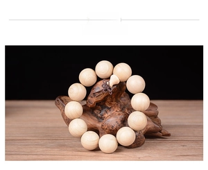 Détail macro de perles en bois de camphrier avec pendentif gourde sur socle