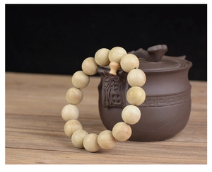 Détail de perles de prière en bois de camphrier naturel contre une théière zen