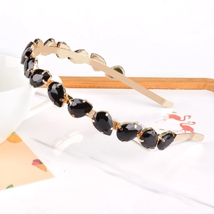 Detail shot of black teardrop crystals set on a slim golden metal headband for women
