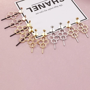 Linear geometric earrings with honeycomb pattern and long metal tassels in gold tones