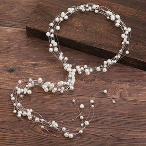 Détail d'un bijou de tête de mariée fait main avec perles sur fond de bois sombre