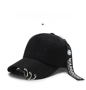 Detail of black baseball cap featuring silver metal rings and long printed ribbon