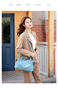 Close-up of blue lychee grain leather tote bag with sturdy handles and metal details