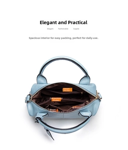 Detail view of the spacious interior with four compartments in a light blue Boston handbag