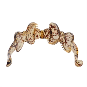 Detailed view of amber tortoise shell pattern hair clip with durable golden metal spring