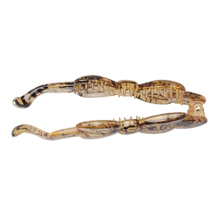 Detailed macro view of the amber resin banana hair clip with dark brown tortoise texture