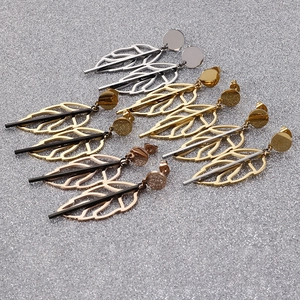 Leaf drop earrings in silver, gold, and rose gold plating on a glittery background