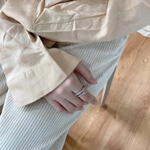 Minimalist double-layered silver ring styled on hand with beige casual clothing