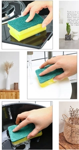 Detail of double-sided kitchen sponge cleaning dishes and stovetop with water drops
