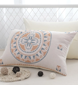 Detail of gauze cotton pillowcase with orange and blue geometric tribal pattern