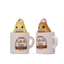 Close-up of cute hamster figurines in coffee cups as fridge magnets for kitchen decor