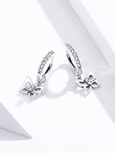 Macro shot of silver butterfly hoop earrings with sparkling zircon crystals