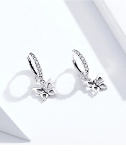 Macro shot of silver S925 butterfly drop earrings with white zircon stone inlay
