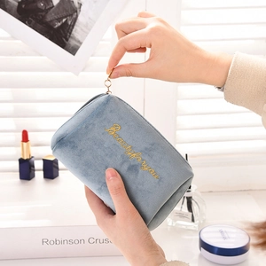 Close-up of blue velvet makeup bag with gold zipper and Beautyforyou embroidery