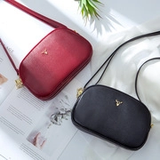 Flat lay of retro leather clutch bags in red and black with gold deer clasp and lychee texture