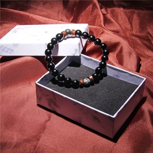 Detail of volcanic stone bracelet with coconut wood chips in a marble gift box