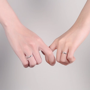 Silver plated couple rings with minimalist sun and moon design on light purple background