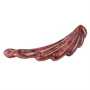 Detail of durable brown amber resin banana hair clip with leaf shape and glossy finish