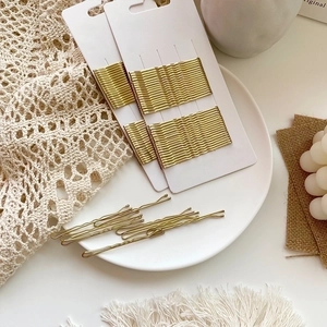 Gold wavy bobby pins for hair styling shown with white display card packaging