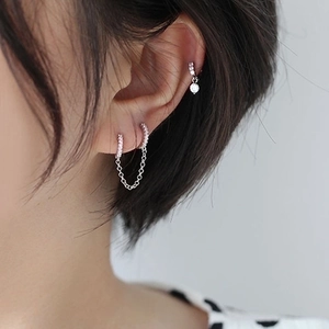 Minimalist silver chain earrings with zircon studs for double piercings on a model