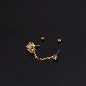 Golden double piercing chain earrings featuring circular moonstone and sparkling zircons