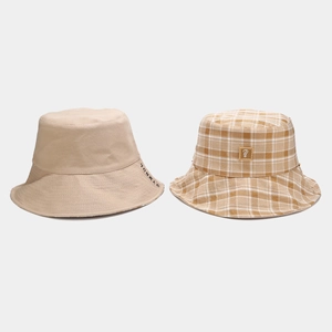 Dettaglio di cappelli alla pescatora reversibili con toppa simbolo e motivo a quadri